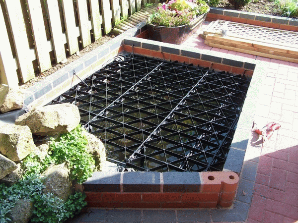 A pond safety cover over a small pond