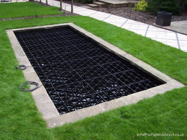 A pond safety cover over a rectangular pond